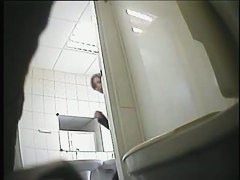 A juicy brunette caught by a spy camera pissing in a public toilet